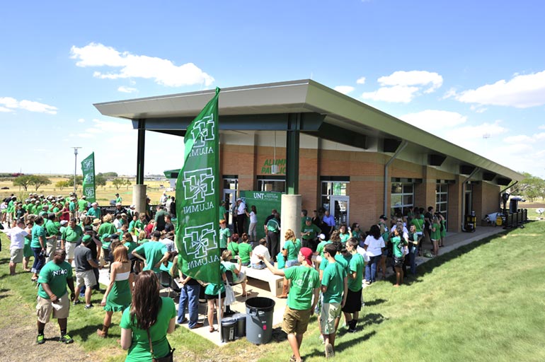 Alumni attending a Homecoming game and tailgating outside the Alumni Pavilion. 