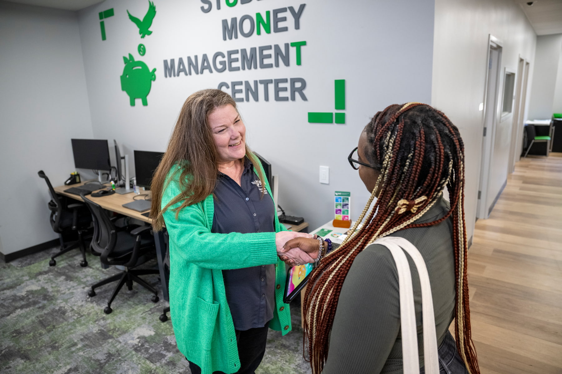 Student shaking hands with a worker at the Money Management Center