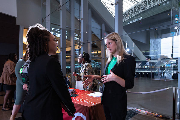 Student speaking to a representative at a graduate job fair. 